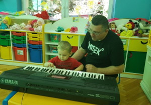 Jaś próbuje zagrać na keyboardzie.