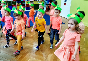 Zajączek zachęca dzieci do szukania marchewek.