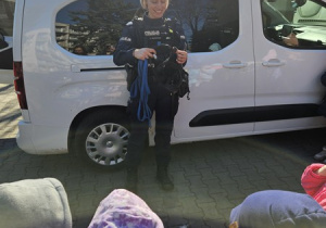 Pani policjantka opowiada o akcesoriach, które nosi pies policyjny.