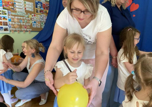 Marysia i jej mama ozdabiają balon.