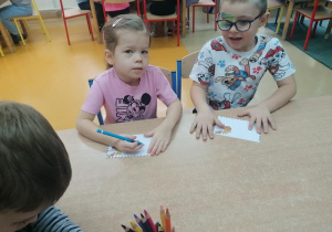 Natalka i Wojtek rysują list.