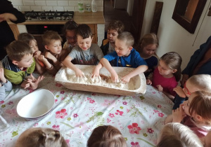 Filipek i Oluś rozpoczynają proces zagniatania ciasta na chleb
