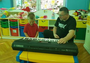 Julek wybiera muzykę na keyboardzie.
