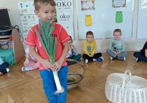 Tymek pokazuje pora, którego wyjął z koszyka.