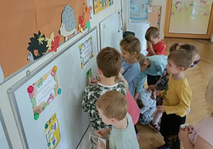 Przedszkolaki segregują owoce i warzywa odnalezione na sali podczas zabawy.