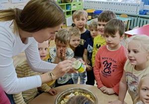 Ciocia Karolina dodaje majonez do sałatki.