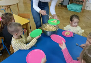 Ciocia Karolina częstuję przedszkolaki sałatką, którą wykonali.