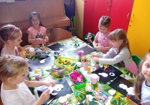 dziewczynki wykonują prace plastyczne z okazji "Dnia Pluszowego Misia"