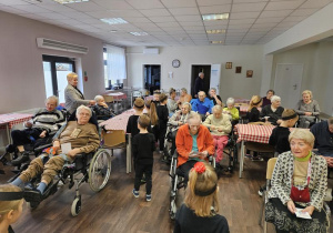 Przedszkolaki rozdają kartki podopiecznym DPS-u.