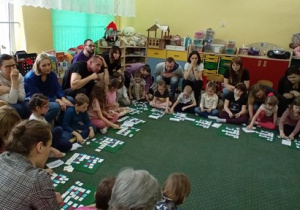 Przedszkolaki umieszczają pod modelami kartoniki z literami