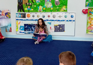 Mama Natalki czyta dzieciom książkę o Reksiu