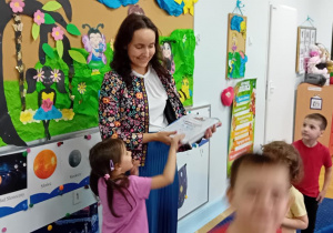 Natalka wręcza mamie dyplom w podziękowaniu za przeczytanie dzieciom książki