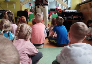 Dzieci słuchają brzmienia instrumentu, który nazywa się okaryna.