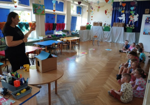 Przedszkolaki słuchają opowieści o tym, jak powstaje miód.
