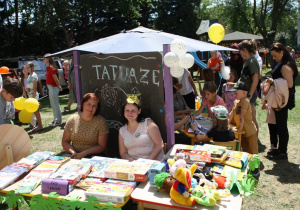 Panie nauczycielki siedzą przy loterii fantowej