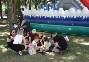 Dzieci ze swoimi rodzicami odpoczywają w cieniu