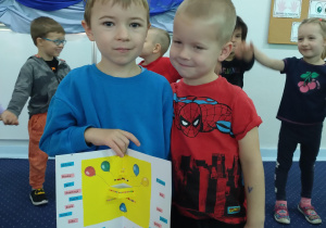 Karol wręcza Dawidkowi urodzinową kartkę w imieniu calej grupy.