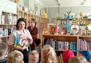 Panie bibliotekarki pokazują dzieciom książki.