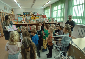 Dzieci wypożyczają książki w bibliotece