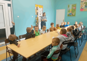Słuchanie książki czytanej przez panią bibliotekarkę.