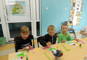 Chłopcy wykonują pracę plastyczną.