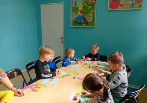 Chłopcy wykonują pracę plastyczną.