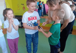 Pani dziennikarka wydaje polecenia dzieciom podczas zabawy.