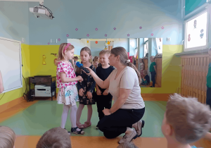Łucja wypowiada się do mikrofonu.