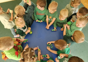 Maluszki oglądają i dotykają zielone przedmioty.