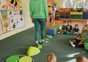 Ciocia Karolinka pokazuje, jak przejść przez ścieżkę sensoryczną.