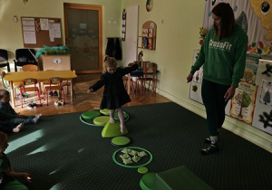 Zuzia idzie po ścieżce sensorycznej.