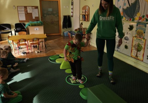 Ignacy z pomocą cioci Karolinki przechodzi po zielonej ścieżce.