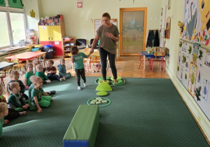 Ciocia Beatka z pomocą Nikodema spaceruje po ścieżce sensorycznej.