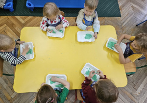 Zabawy sensoryczne przy żółtym stole.