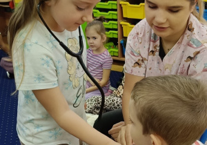 Kaja bada Jasia stetoskopem.