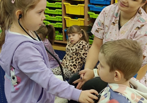 Laura bada Jasia stetoskopem.