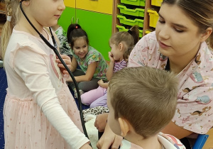 Emilka bada Jasia stetoskopem.