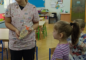 Julia wręcza upominek gościowi.