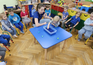 Lena za pomocą magnesu wyławia pierwszy obrazek z niebieskiej wody.