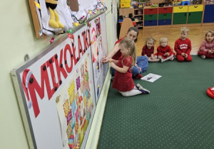 Matylda przyczepia obrazek na tablicę.