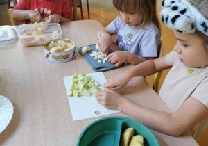 Julek i dziewczynki kroją jabłka.