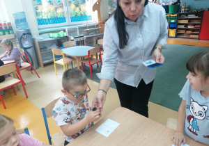 Wojtek będzie naklejał znaczek.