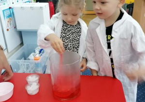 Kajtek i Kaja przeprowadzają doświadczenie.