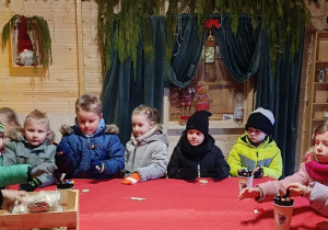 Dzieci wybierają ozdoby choinkowe.