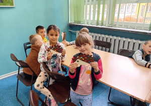 Dziewczynki prezentują wykonane jeżyki z papieru.