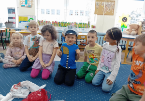 Chłopiec przymierza czapkę policjanta.