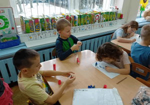 Dzieci wykonują pracę plastyczną.