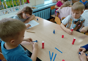 Dzieci wykonują pracę plastyczną.