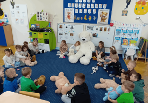 Dzieci podczas zabawy muzycznej "Kto przytuli misia tulisia".