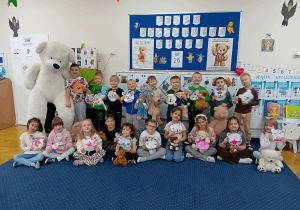 Grupowe zdjęcie z wykonanymi przez dzieci misiami z papieru.